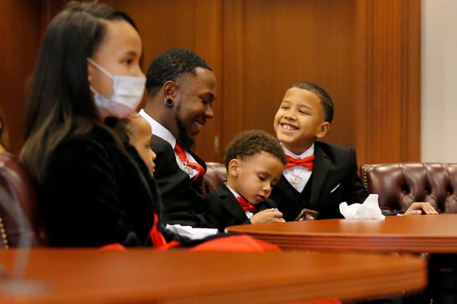 Robert Carter smiles with his five new children as Magistrate Rogena Stargel officially approves their adoption at the Hamilton County Probate Court in downtown Cincinnati on Friday, Oct. 30, 2020.