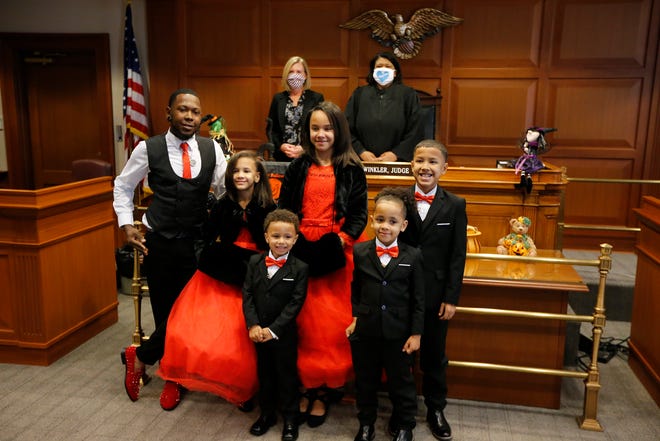 Robert Carter smiles with his five new children as Magistrate Rogena Stargel officially approves their adoption during a ceremony on Friday, Oct. 30, 2020.