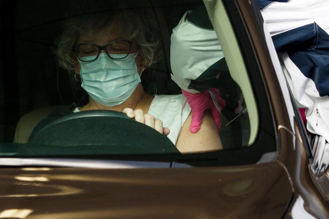 Hamilton County Health Department worker Shelly Donahue gives a shot of the COVID-19 vaccine to a woman on Wednesday at a drive-thru vaccination site in Chattanooga, Tenn.