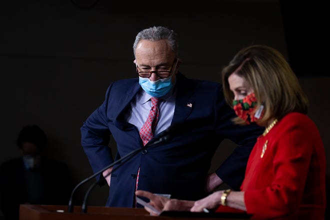 Senate Minority Leader Chuck Schumer, D-N.Y., listens as Speaker of the House Nancy Pelosi, D-Calif., speaks during a press conference on Capitol Hill on Dec. 20, 2020, in Washington, D.C.