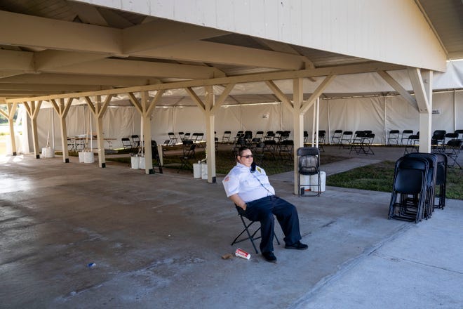 Security guard Andrea Rapini sits at a COVID-19 vaccination site that closed after running out of the vaccine in John Prince Park in Lake Worth Beach, Fla., on Jan. 27. Gov. Ron DeSantis turned  vaccine distribution over to Publix pharmacies in the area.