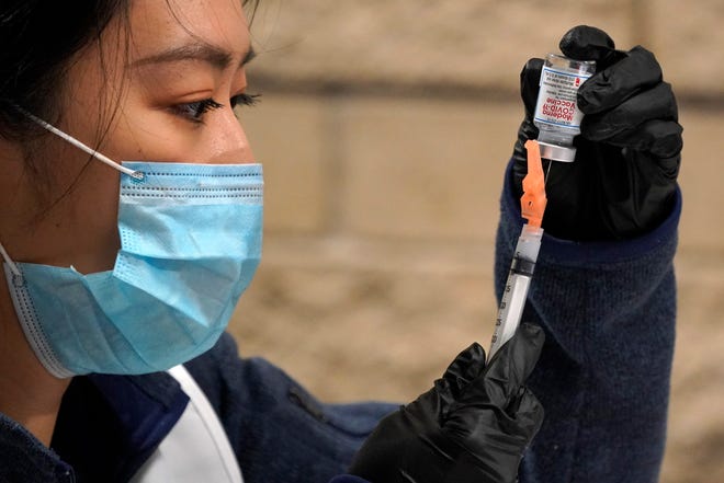 University of Pittsburgh pharmacy student Edith Wang fills a syringe with a dose of the Moderna COVID-19 vaccine during a vaccination clinic on Thursday at the Petersen Events Center in Pittsburgh.