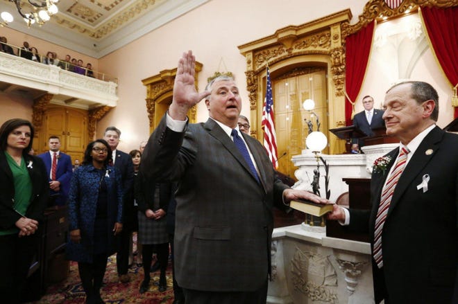 Rep. Larry Householder, center, takes the oath of office after being elected as the new Speaker of the Ohio House. Veteran Democratic lawmaker David Leland of Columbus, right, who helped broker the deal that gave the Republican the top spot, assisted in the January 2019 ceremony.