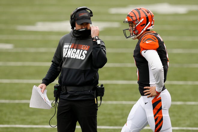 Cincinnati Bengals head coach Zac Taylor and quarterback Joe Burrow (9) discuss a play during a timeout in the fourth quarter of the NFL Week 7 game between the Cincinnati Bengals and the Cleveland Browns at Paul Brown Stadium in downtown Cincinnati on Sunday, Oct. 25, 2020. The Bengals and Browns exchanged late touchdowns, finishing in a 37-34 win for the Browns.