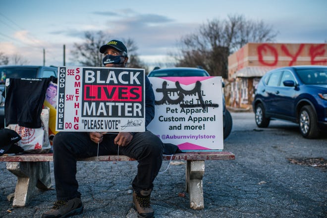 A Black Lives Matter supporter encourages people to vote Jan. 4 in Atlanta.