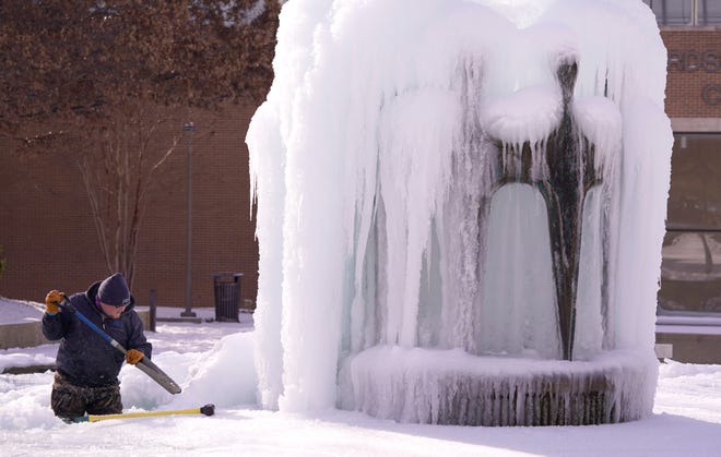 City of Richardson worker Kaleb Love works to clear ice from a water fountain Tuesday, Feb. 16, in Richardson, Texas.