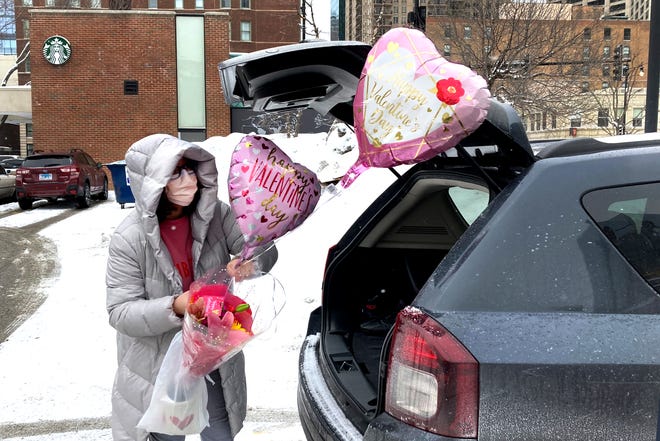 Ellen Yun loads Valentine's Day gifts for her mom, sister and brother in-laws, nephew and her two children Saturday, Feb. 13, 2021, outside a Chicago area grocery store. Yun said she had shopped for her husband earlier.