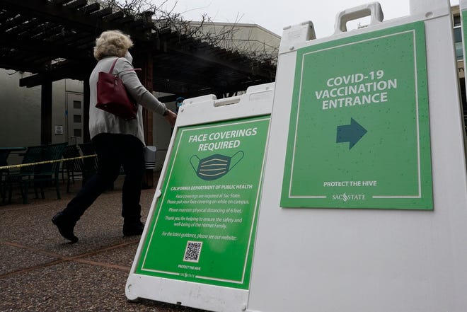 A woman follows signs to a recently opened COVID-19 vaccination center at Sacramento State University in California on Tuesday.