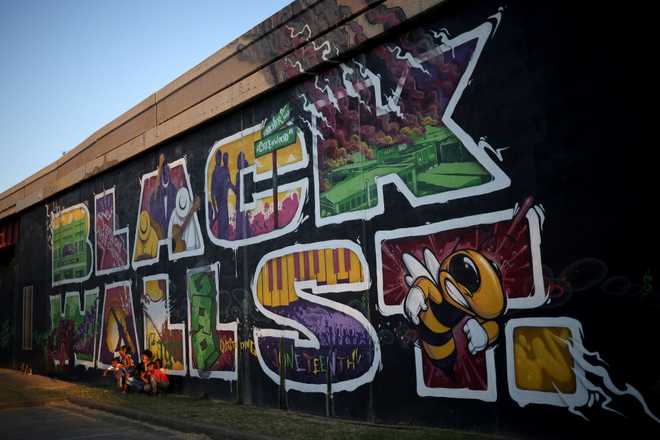TULSA,&#x20;OKLAHOMA&#x20;-&#x20;JUNE&#x20;18&#x3A;&#x20;Children&#x20;pose&#x20;for&#x20;a&#x20;photo&#x20;in&#x20;front&#x20;of&#x20;a&#x20;mural&#x20;marking&#x20;Black&#x20;Wall&#x20;Street,&#x20;also&#x20;called&#x20;the&#x20;Greenwood&#x20;Distric,&#x20;June&#x20;18,&#x20;2020&#x20;in&#x20;Tulsa,&#x20;Oklahoma.&#x20;The&#x20;Black&#x20;Wall&#x20;Street&#x20;Massacre&#x20;happened&#x20;in&#x20;1921&#x20;and&#x20;was&#x20;one&#x20;of&#x20;the&#x20;worst&#x20;race&#x20;massacres&#x20;in&#x20;the&#x20;history&#x20;of&#x20;the&#x20;United&#x20;States&#x20;where&#x20;more&#x20;than&#x20;35&#x20;square&#x20;blocks&#x20;of&#x20;a&#x20;predominantly&#x20;black&#x20;neighborhood&#x20;were&#x20;destroyed&#x20;in&#x20;two&#x20;days&#x20;of&#x20;rioting&#x20;leaving&#x20;between&#x20;150-300&#x20;people&#x20;dead.&#x20;&#x28;Photo&#x20;by&#x20;Win&#x20;McNamee&#x2F;Getty&#x20;Images&#x29;