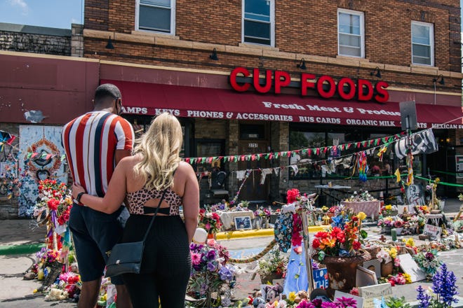 A couple pay their respects to George Floyd at the intersection of 38th Street and Chicago Avenue on May 25 in Minneapolis. Around the USA, groups honored George Floyd, who was murdered by Minneapolis police officer Derek Chauvin on May 25, 2020.