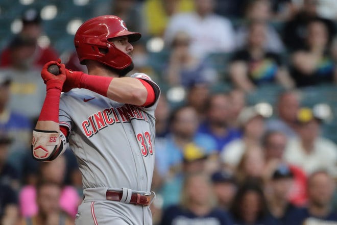 Cincinnati Reds' Jesse Winker hits an RBI-single during the second inning of a baseball game against the Milwaukee Brewers, Monday, June 14, 2021, in Milwaukee.