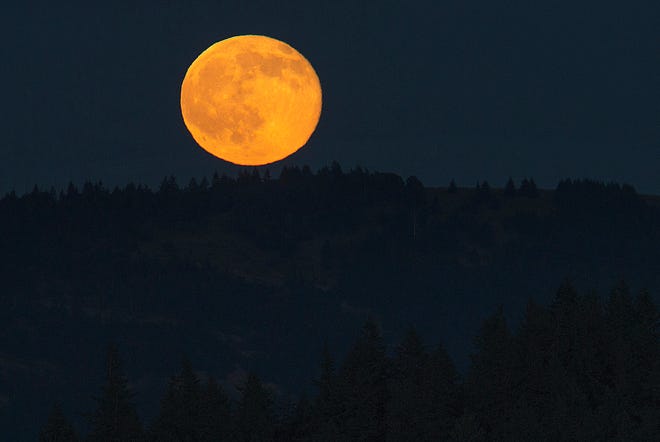 A Strawberry Moon rises over the Willamette Valley as seen from Skinner Butte in Eugene, Oregon in 2016.