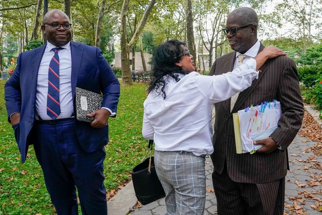 R. Kelly supporter Carlotte Woods, center, of Kentucky, hugs his attorney Deveraux Cannick, right, as he returns to court after a lunch break in the R&B star's trial on Aug. 19, 2021, in New York.