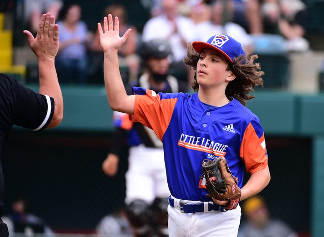 Michigan starting pitcher Ethan Van Belle high fives his coach after retiring the side in the second inning of the Little League World Series championship game.
