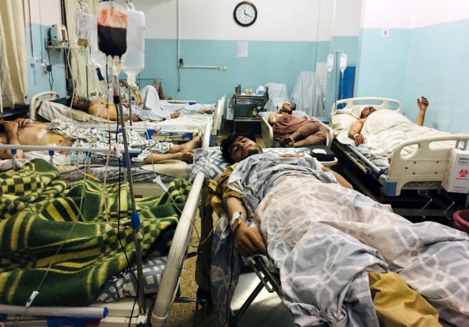 Wounded Afghans lie on a bed at a hospital after an attack on the airport in Kabul, Afghanistan, on Aug. 26, 2021.