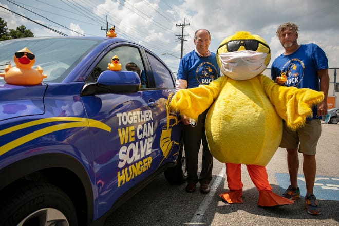 Mark Bodnar, the current chair of the Rubber Duck Regatta steering committee and Mick Clay, the Freestore's director of development operations, stand with 'Quacky' at the Freestore Foodbank on Aug. 18, 2021.