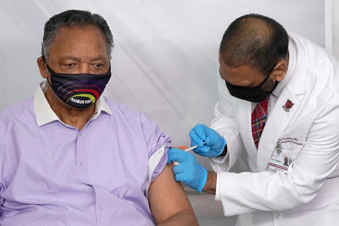 Rev. Jesse Jackson receives the Pfizer's BioNTech COVID-19 vaccine Friday, Jan. 8, 2021, from Dr. Kiran Chekka, Covid Administration Physician at the Roseland Community Hospital in Chicago.
