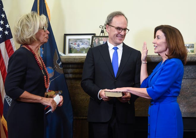 New York Chief Judge Janet DiFiore, left, swears in Kathy Hochul, right, as the first woman to be New York's governor. Her husband Bill Hochul holds a bible during a swearing-in ceremony in the governor's office at the state Capitol, early Tuesday, Aug. 24, 2021, in Albany, N.Y.