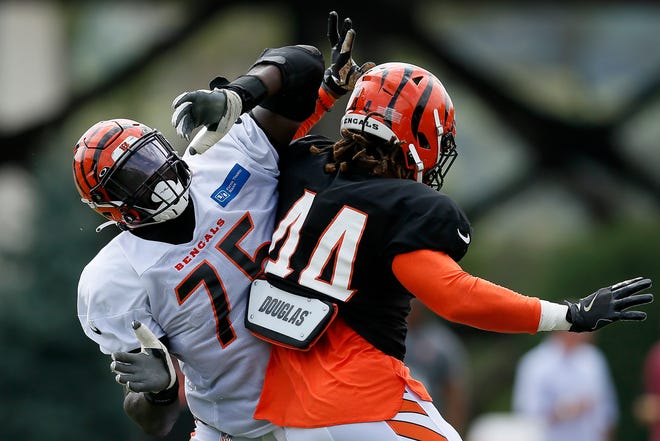 Cincinnati Bengals linebacker Darius Hodge (44) pushes around offensive tackle Isaiah Prince (75) during a training camp practice at the Paul Brown Stadium training field in downtown Cincinnati on Wednesday, Aug. 4, 2021.