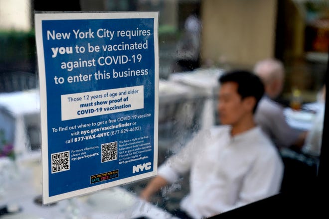 A sign explaining that proof of COVID-19 vaccination is required is seen at a restaurant in midtown Manhattan on Monday.