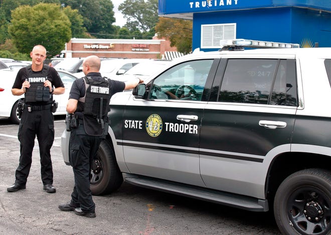 Members of the North Carolina State Highway Patrol talk in a shopping center parking lot in Winston-Salem, N.C., on Wednesday, Sept. 1, 2021. The troopers were part of the law enforcement response after a student was shot and killed at Mount Tabor High School.