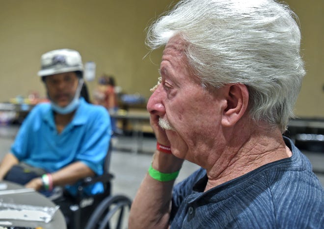 Having lunch at the evacuation center at the Reno-Sparks Convention Center, Timothy Pritchard wipes a tear away as he talks about what he left behind at his South Lake Tahoe home. Next to him is newfound friend Paul Brooks who had to call 911 to help him get out because he's in a wheelchair.