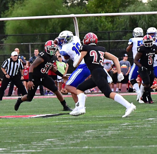 Devin Hyatt (16) of IMG Academy gets makes a reception and is then sandwich tackled by La Salle's Deyor Brumfield (32) and Jack Fries (23), turning the ball over to the Lancers, Sept. 3, 2021.