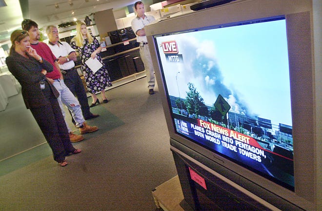 Employees and customers at Art's TV and Appliance in Mary Esther watch news reports of the terrorist attacks on the World Trade Center and the Pentagon on Tuesday Sept. 11, 2001.