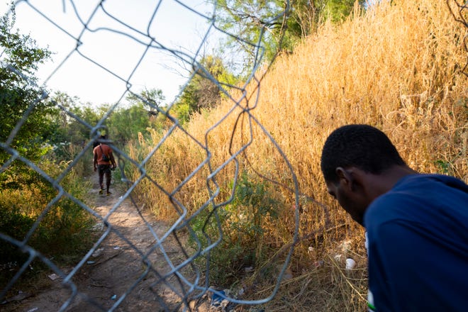 Haitian migrants walk back from Del Rio, Texas to Ciudad Acuna to get food and water. 