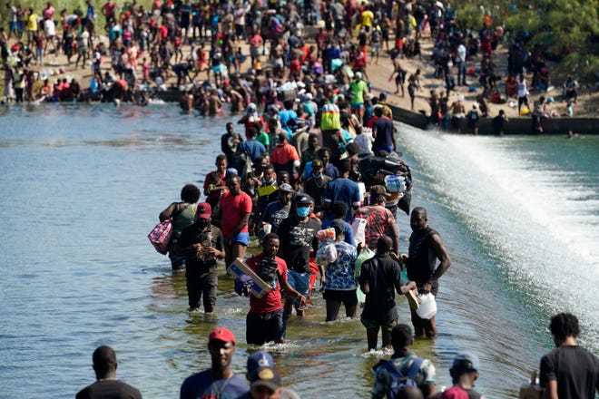 Haitian migrants use a dam to cross to and from the United States from Mexico, Friday, Sept. 17, 2021, in Del Rio, Texas. Thousands of Haitian migrants have assembled under and around a bridge in Del Rio presenting the Biden administration with a fresh and immediate challenge as it tries to manage large numbers of asylum-seekers who have been reaching U.S. soil.