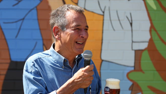 Samuel Adams founder Jim Koch gives remarks during the unveiling a mural facing Central Parkway, depicting the community's significant brewing history and vibrant future.
