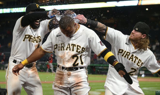 Sep 15, 2021; Pittsburgh, Pennsylvania, USA;  Pittsburgh Pirates outfielders Anthony Alford (left) and Ben Gamel (right) pour water on pinch hitter Wilmer Difo (front) after Difo scored the game winning run to defeat the Cincinnati Red at PNC Park. The Pirates won 5-4. Mandatory Credit: Charles LeClaire-USA TODAY Sports