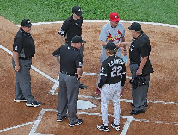Umpire Joe West #22 and his crew Dan Bellino #2, Nic Lentz #59 and Bruce Dreckman #1 are greeted by manager Tony La Russa #22 of the Chicago White Sox and manager Mike Shildt #8 of the St. Louis Cardinals as West prepares to umpire a record breaking 5,367th game at Guaranteed Rate Field on May 25, 2021 in Chicago, Illinois.