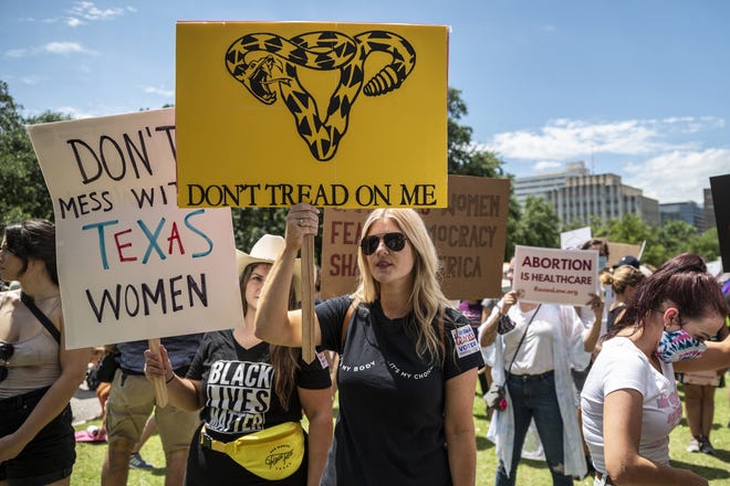 In this photo from May 29, 2021, protesters hold up signs at a protest outside the Texas state capitol in Austin, Texas. Thousands of protesters came out in response to a new bill outlawing abortions after a fetal heartbeat is detected signed on Wednesday by Texas Gov. Greg Abbott. (Sergio Flores/Getty Images/TNS)