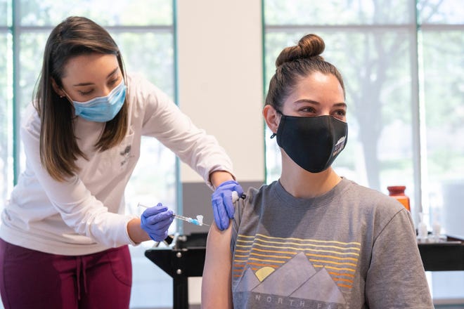 This photo provided by New Mexico State University shows Aggie Health and Wellness Center nurse Marissa Archuleta (left) administering a Johnson & Johnson COVID-19 vaccine to Lauren Naranjo at a walk-in clinic at Corbett Center in Las Cruces, New Mexico.
