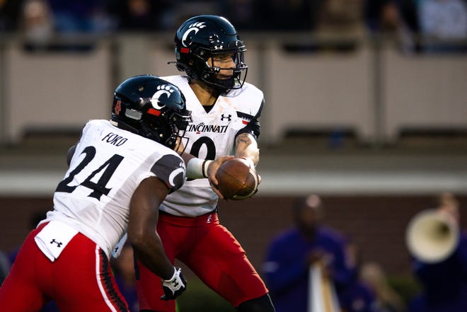 Cincinnati Bearcats quarterback Desmond Ridder (9) hands the ball off to Cincinnati Bearcats running back Jerome Ford (24) in the first half of the NCAA football game between the Cincinnati Bearcats and the East Carolina Pirates at Dowdy-Ficklen Stadium in Greenville, NC, on Friday, Nov. 26, 2021.