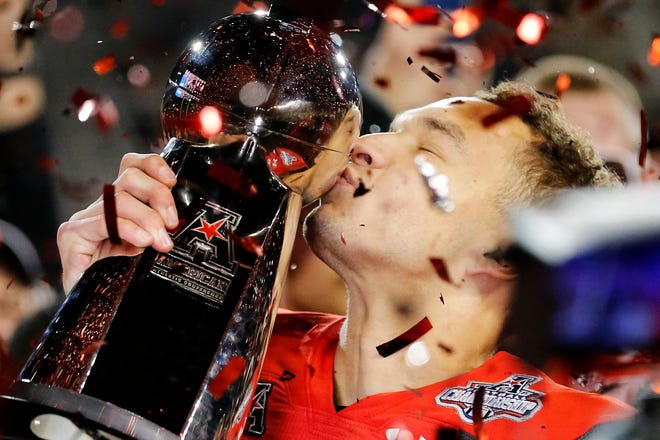 Cincinnati Bearcats quarterback Desmond Ridder (9) kisses the American Athletic Conference Championship trophy during a ceremony after the American Athletic Conference Championship football game between the Cincinnati Bearcats and the Houston Cougars at Nippert Stadium in Cincinnati on Saturday, Dec. 4, 2021. The Bearcats remained unbeaten as they won the AAC Championship with a 35-20.
