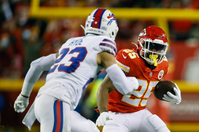 Kansas City Chiefs running back Clyde Edwards-Helaire (25) runs from Buffalo Bills safety Micah Hyde (23) during the first half of an NFL divisional round playoff football game, Sunday, Jan. 23, 2022, in Kansas City, Mo. (AP Photo/Colin E. Braley)