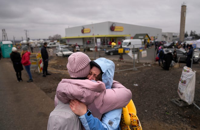 A woman weeps after finding a friend, who also fled Ukraine, at the border crossing in Medyka, Poland, Saturday, March 5, 2022.