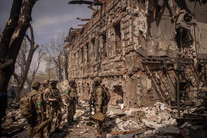 Members of the Ukrainian military walk amid debris after a shopping center and surrounding buildings were hit by a Russian missile strike on April 16, 2022, in Kharkiv, Ukraine. After Russian forces retreated from areas around Kyiv, recent reports point to a new offensive as Russian forces have regrouped in the eastern part of the country bringing fears of an escalation of violence.