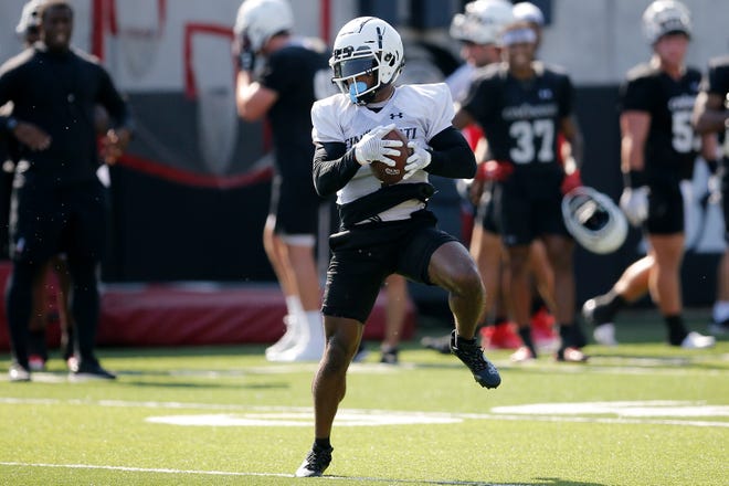 Bearcats receiver Tre Tucker (1) catches a pass during the first day of preseason training camp at the University of Cincinnati’s Sheakley Athletic Complex in Cincinnati on Wednesday, Aug. 3, 2022.
